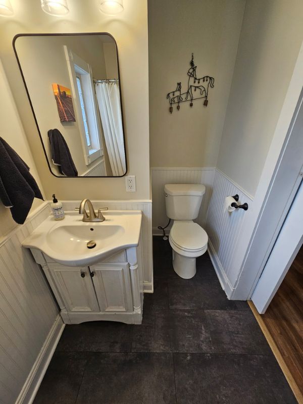 Elevated shot of updated charcoal grey tile flooring in a main floor bathroom.