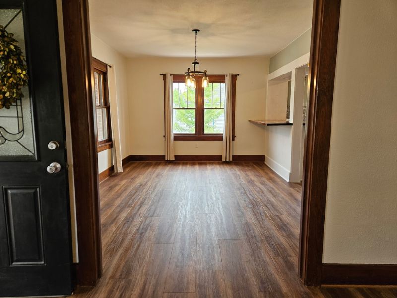 Entryway into dining room of home, completed with deep brown new flooring.