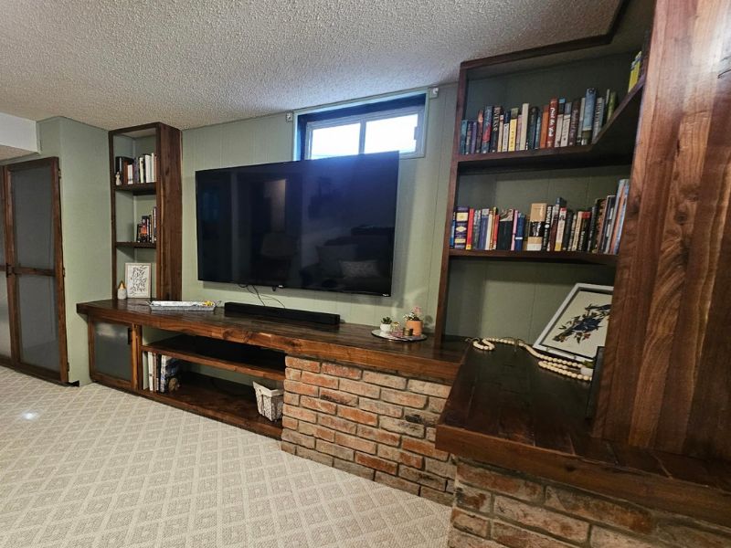 Large, wooden custom bookshelves featuring glass-front cabinetry.