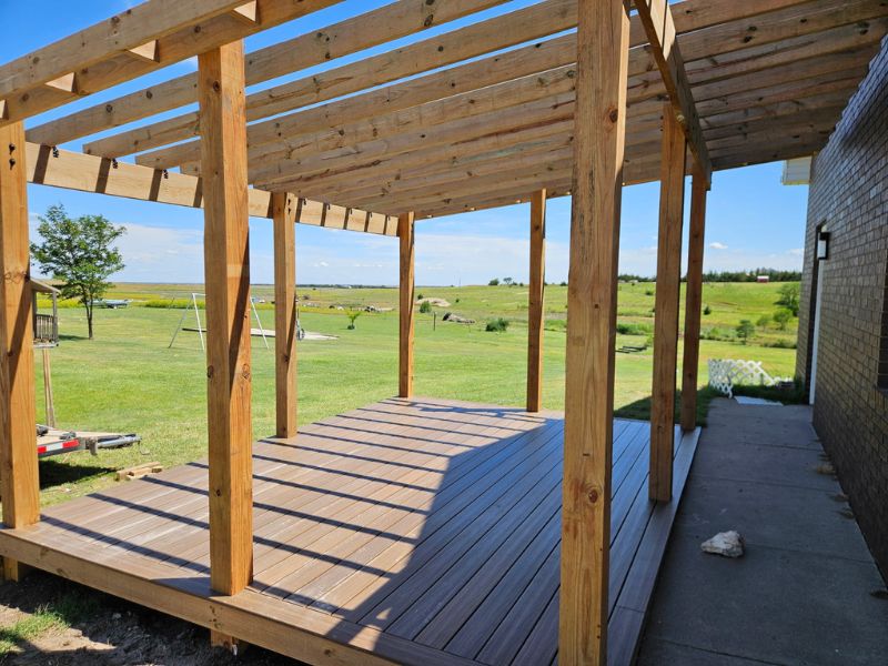 Landscape side view of outdoor deck and patio with natural wood covering.