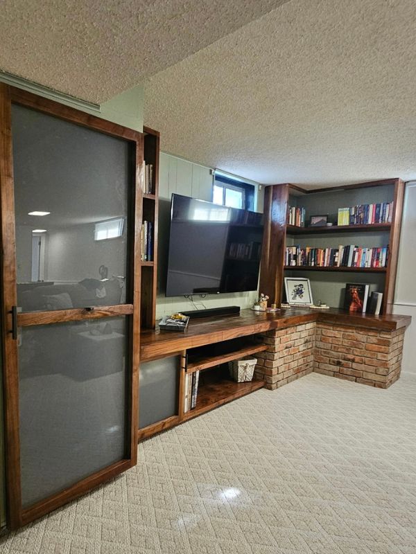 Custom wood shelving and cabinetry holding books and decoration.