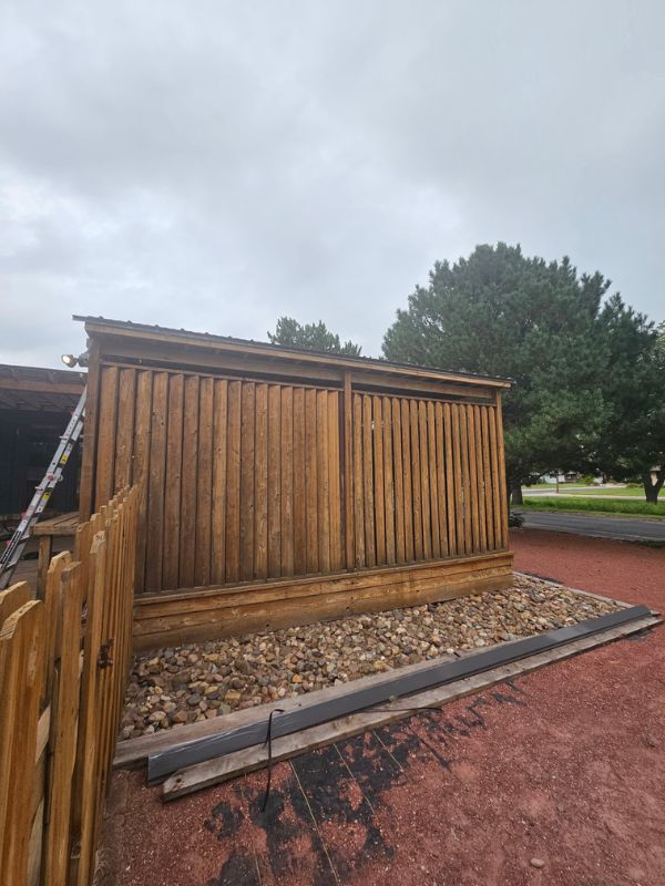 Outside of a wood covered patio with natural trees in the background.