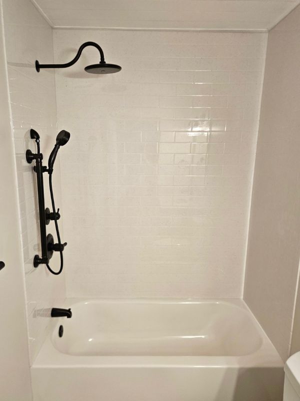 White Onyx shower and bathtub with black fixtures as an accent.