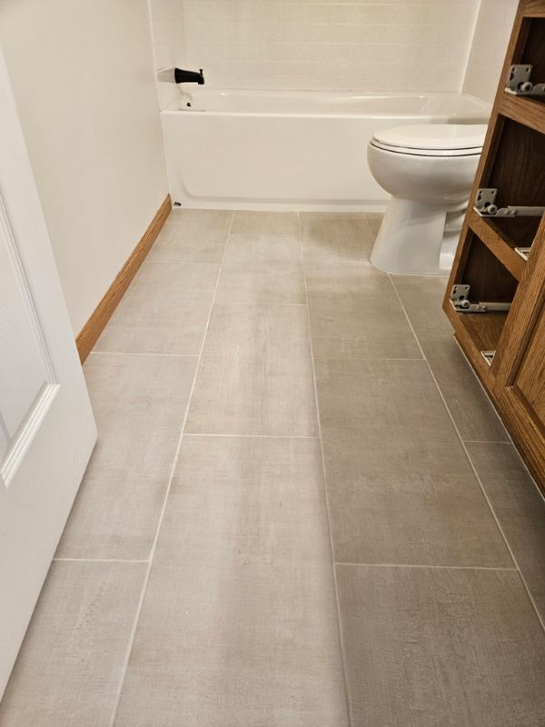 Slate grey tile flooring in a renovated bathroom by Seymour Construction LLC.
