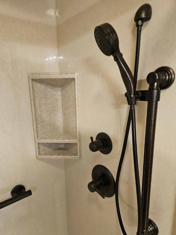 Detailed view of the high-end fixtures installed in an Onyx shower by Seymour Construciton LLC.
