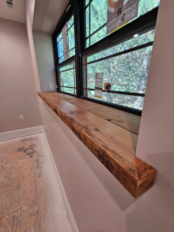 Custom barn wood windowsill in a bedroom in an in-progress two bedroom, one bathroom home addition.